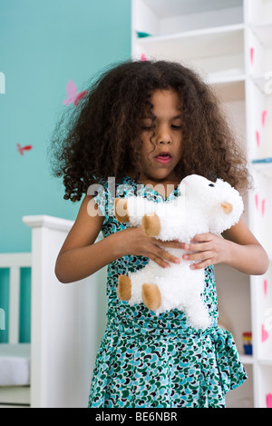 Little girl holding stuffed sheep Stock Photo
