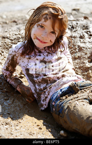 Child totally covered in mud, dirty, wild, untypical girl Stock Photo