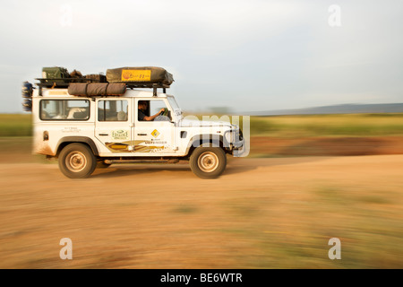 Land Rover Defender driving through the Kabwoya Wildlife Reserve in western Uganda. Stock Photo