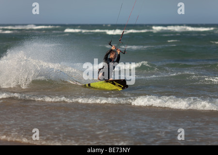 A kite surfer turns tightly close to shore. Stock Photo