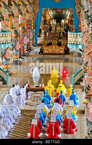 Monks and nuns praying, holy altar 'the eye', ceremonial midday prayer in the Cao Dai temple, Tay Ninh, Vietnam, Asia Stock Photo