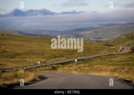 Empty winding country road heading into a mist shrouded valley on the Isle of Skye, Scotland Stock Photo