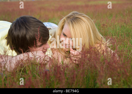 Young couple in love, lying in a meadow Stock Photo