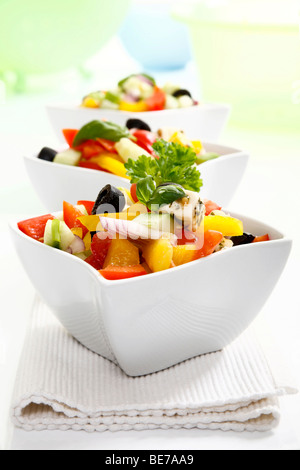 Greek salad with onions, tomatoes, capsicum, feta and olives in small bowls Stock Photo