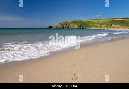 Footprints emerge from the waves on sandy beach Stock Photo