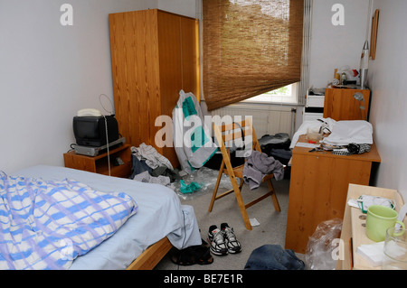 Untidy, cluttered bedroom in disarray, messy bed boys room Stock Photo