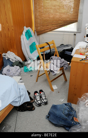 Untidy, cluttered bedroom in disarray, messy bed boys room Stock Photo