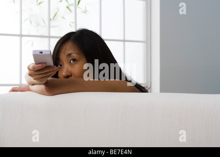 Woman using remote control Stock Photo