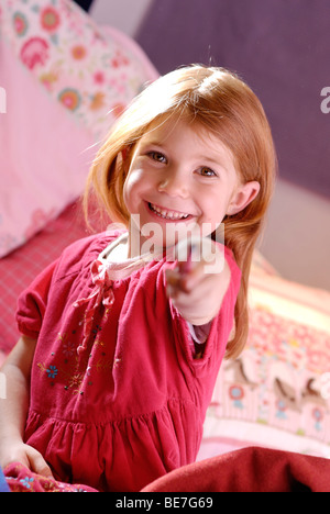Little girl holding a pen in her hand Stock Photo