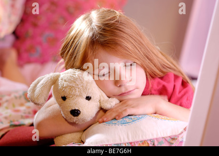 Little girl sleeping with a stuffed toy dog Stock Photo