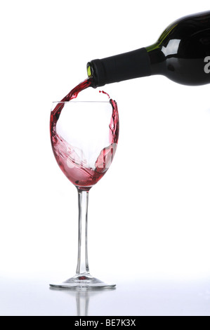 Red wine poured on glass isolated against a white background Stock Photo