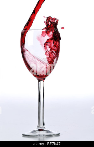 Red wine poured on glass isolated against a white background Stock Photo