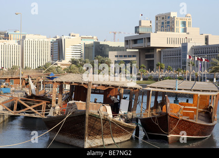 Working dhows moored at the harbour on Doha's Corniche, in Qatar, Arabia. In the background are buildings  from the 60s and 70s. Stock Photo