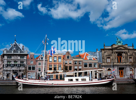 Boat moored on River Spaarne and historic houses in Haarlem Netherlands Stock Photo