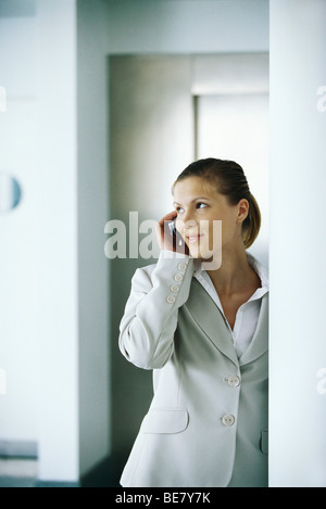 Businesswoman using cell phone, glancing away Stock Photo