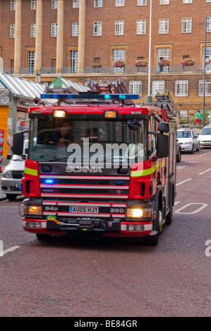 A fire engine speeding through the city centre in Norwich , Norfolk , Uk with blue lights flashing showing movement Stock Photo
