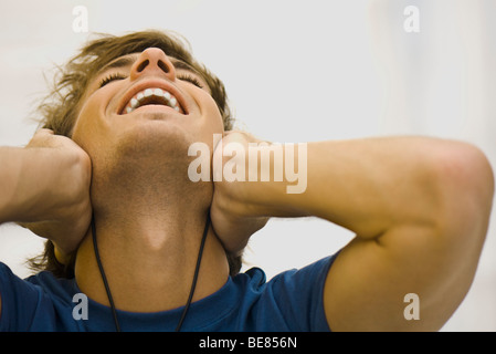 Man listening to headphones, leaning head back smiling Stock Photo