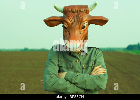 Person wearing bull mask, arms folded across chest Stock Photo