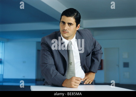 Businessman staring intently at camera with clenched fist on table Stock Photo
