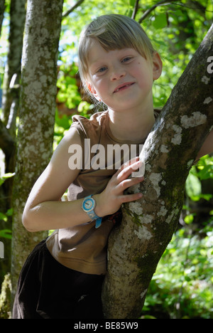 Little girl, 7 years old, climbing a tree