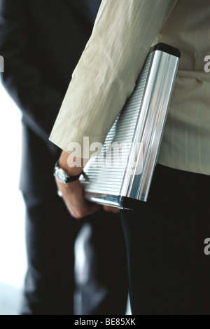 Businesswoman carrying briefcase under arm in conversation with colleague, mid section Stock Photo