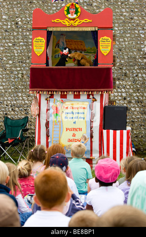 ENGLAND West Sussex Findon Village Sheep Fair Punch And Judy Show with audience of children sitting on ground watching puppets. Stock Photo