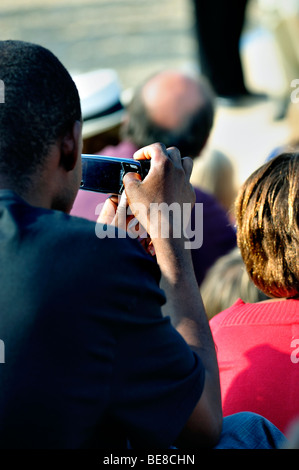 Paris, France - Black Man Taking Photos with Cellphone at Public Event Stock Photo