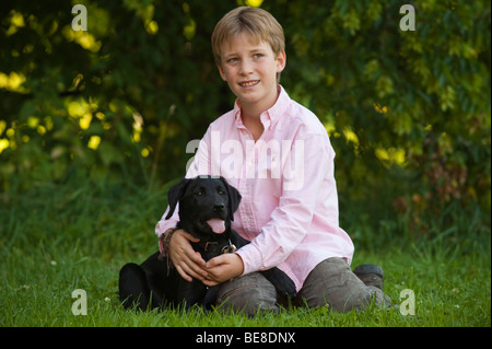 Boy, 10, with a labrador puppy Stock Photo