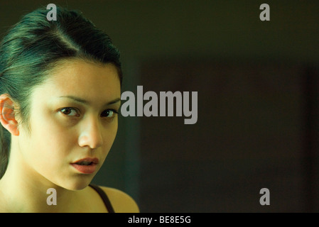 Young woman scowling at camera, portrait Stock Photo