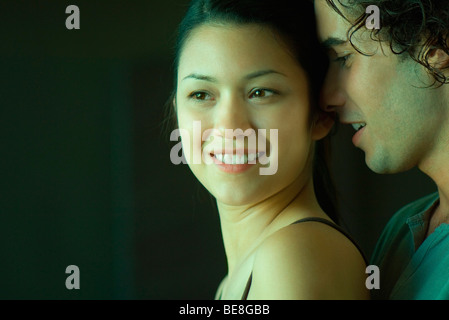 Young couple, man whispering in woman's ear Stock Photo