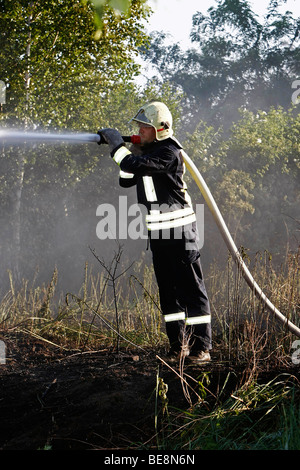 Firefighter extinguishing a fire Stock Photo