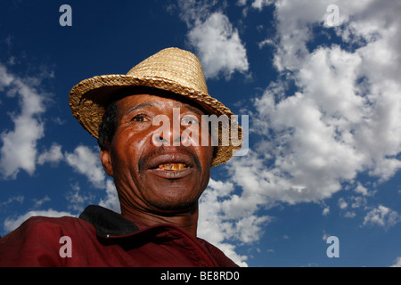 wearing straw hat harvesting broccoli 