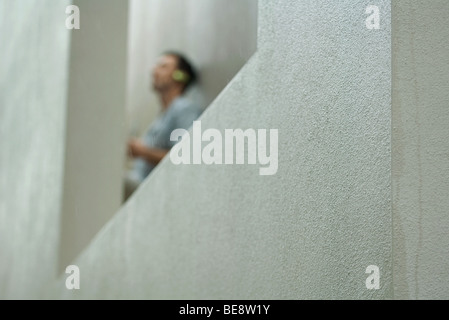 Man leaning against wall, focus on concrete in foreground Stock Photo