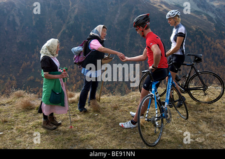 Bicycle racers with the berry pickers at the Passo di Pennes road, South Tyrol, Italy, Europe Stock Photo