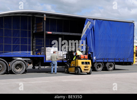 A forklift truck loads unloads a double deck curtainsided trailer and truck