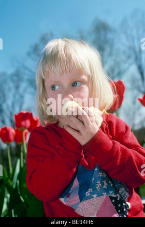 Kissing chicks: Young girl holding a baby chick sneaks a kiss, Midwest USA Stock Photo
