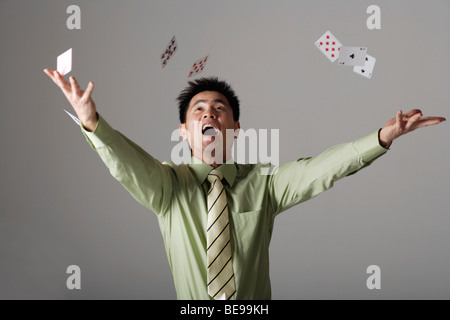 man throwing cards up into the air Stock Photo