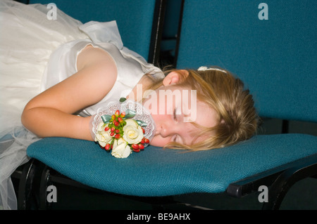 Young Bridesmaid Asleep On Chairs Stock Photo