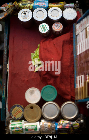 A Paan wallah's stall with cigarette packets and pots of paste for making paan in Old Delhi, India Stock Photo