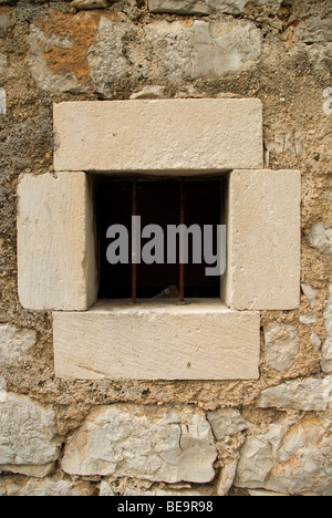 Croatia; Hrvartska; Kroatien; Šibenik-Knin, Privč, Šepurine, window framed with large stone blocks, in stone wall, iron bars Stock Photo