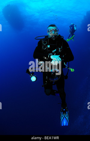 Scuba diver holding a camera in the Red Sea Stock Photo