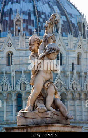Statue of cherubs near the leaning tower with the Baptistery in the background Stock Photo