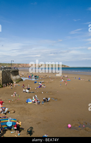 dh Filey beach FILEY NORTH YORKSHIRE Holidaymakers bathing on sandy holiday resort seaside coast summer deckchair Stock Photo