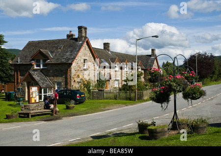 dh  ACHARN PERTHSHIRE Two Hikers waiting at bus stop in Loch Tay village cottages stone scotland remote rural scottish highlands Stock Photo