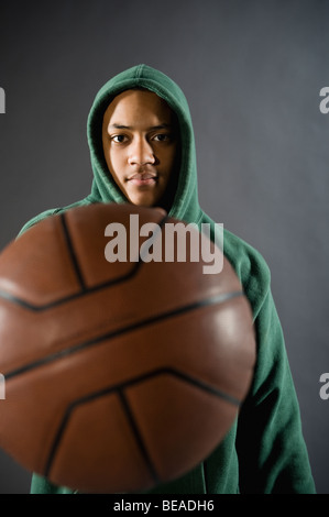 Mixed race boy holding basketball Stock Photo