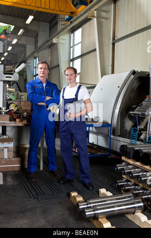 Portrait of two manual workers in a metal parts factory Stock Photo