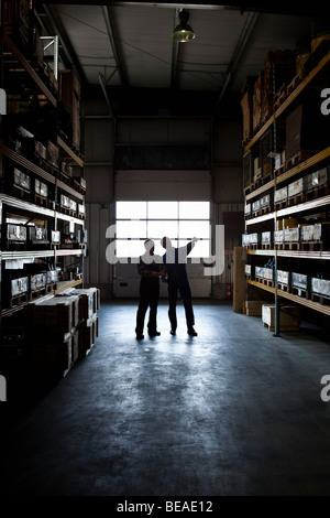Two manual workers in a metal parts warehouse Stock Photo