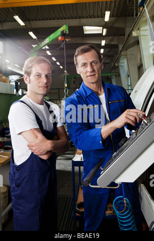 Two manual workers in a metal parts factory Stock Photo