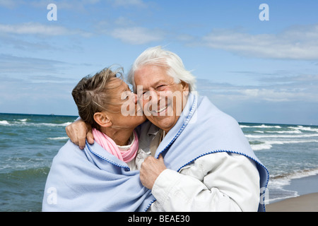 A senior couple walking on a beach together Stock Photo