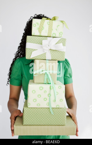 A woman holding a stack of gifts Stock Photo